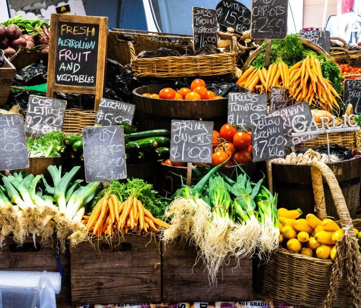 A table of fresh fruits and veggies for sale at a market